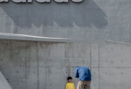 Branding - Man Taking Photo of a Child Leaning on Wall