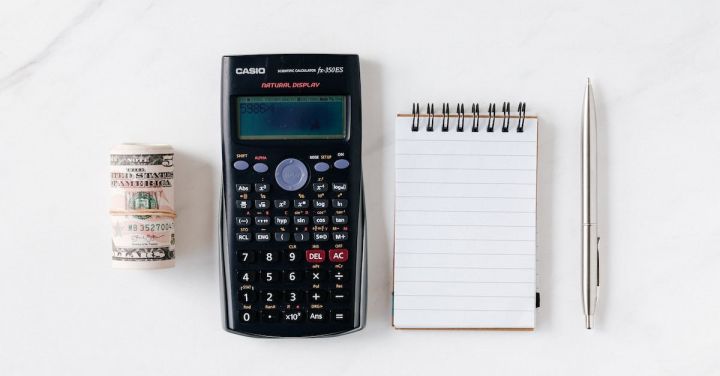 Budgeting - Composition of calculator with paper money and notebook with pen