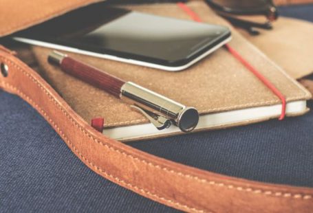 Branding - Smartphone Displaying Black Screen on Notebook Beside Pen and Sunglasses