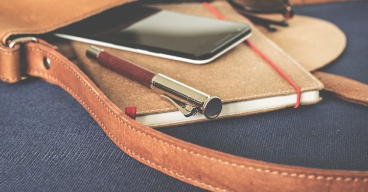 Branding - Smartphone Displaying Black Screen on Notebook Beside Pen and Sunglasses