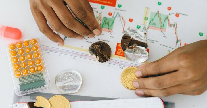 Financial Management - Person Holding Chocolate Coins on White Paper