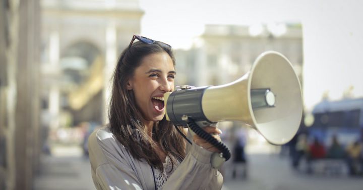 Marketing Campaigns - Cheerful young woman screaming into megaphone