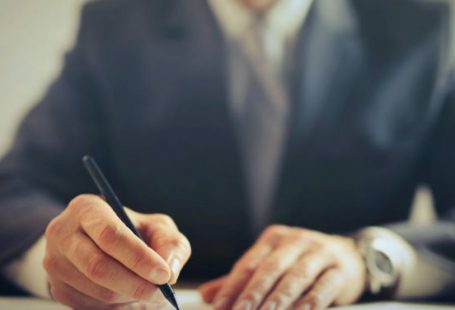 Professional Connections - Crop businessman signing contract in office