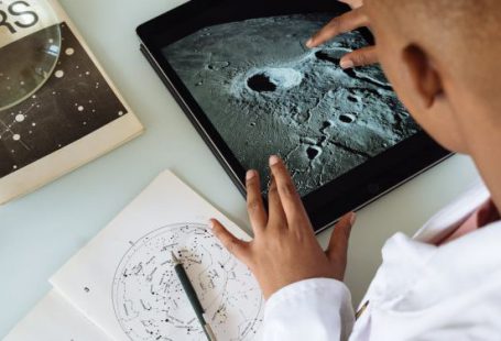 Professional Connections - Crop African American student studying craters of moon on tablet at observatory