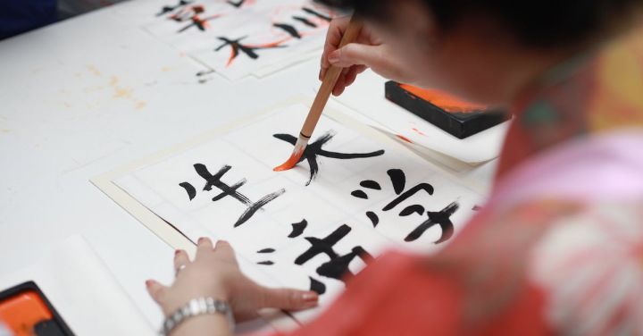 Up Graph - Person Holding Brush Drawing Kanji Script